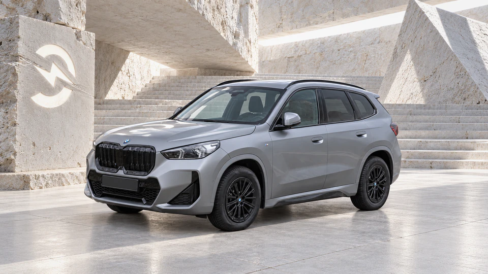 BMW iX1, вид спереди в три четверти, в студии Электроатласа